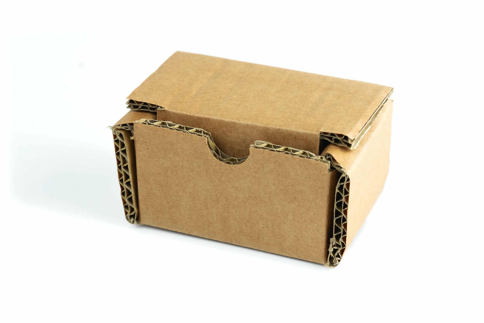 A small, empty, unopened brown cardboard box is isolated on a clean white background, ideal for packaging or shipping.