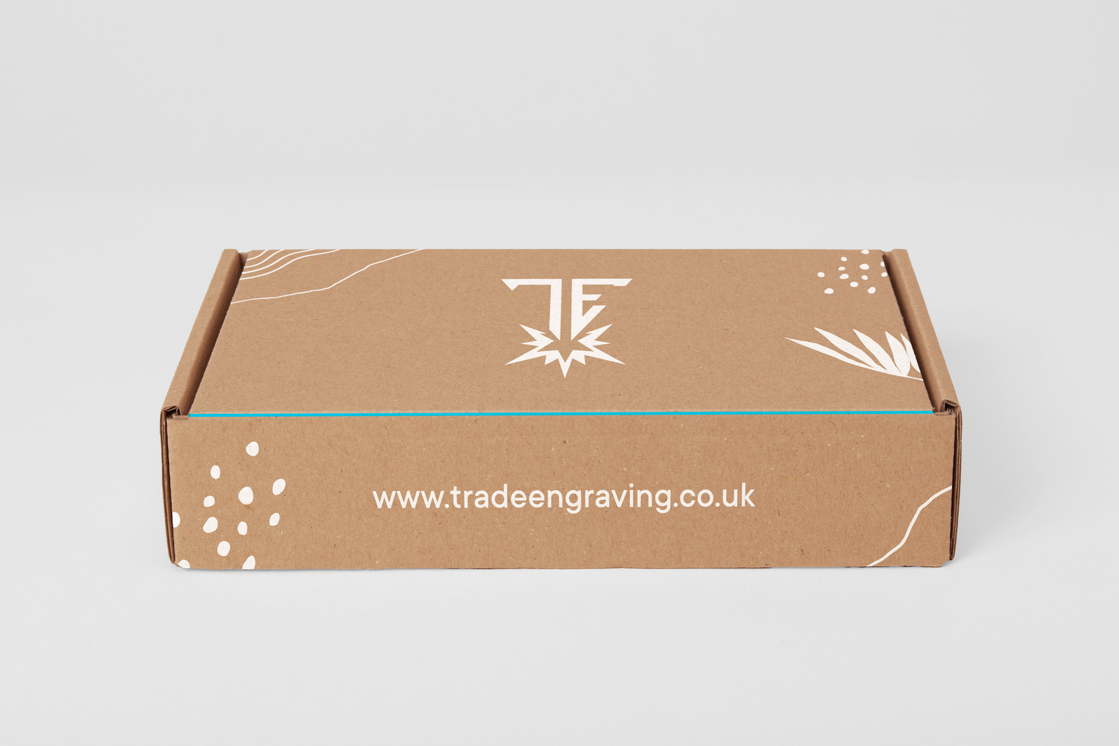 Brown cardboard shipping box with 'TRADE ENGRAVING' logo and www.tradeengraving.co.uk website printed in white.
