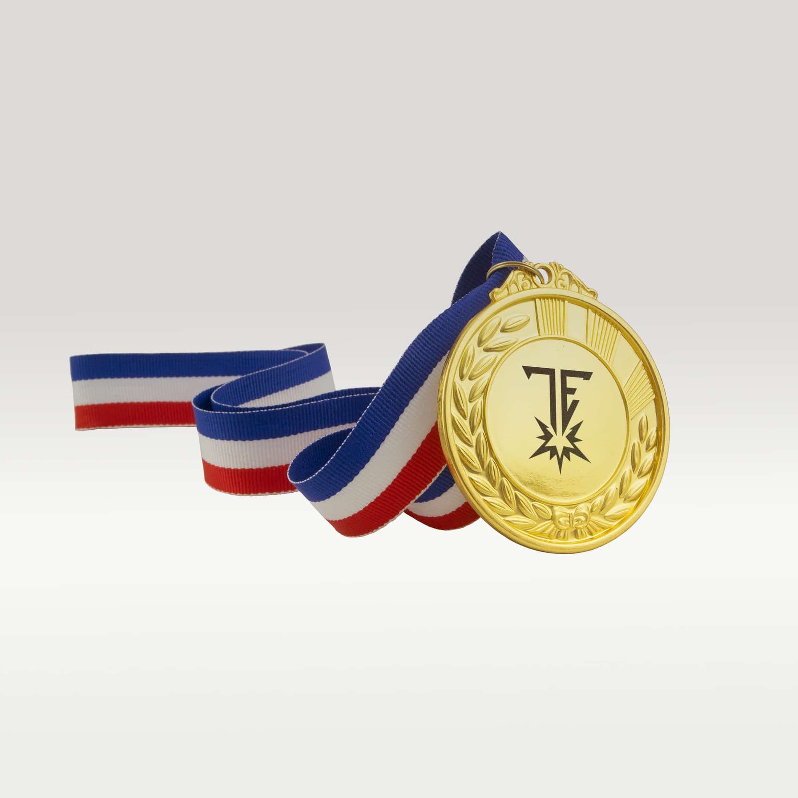 Shiny gold medal with custom logo and a red, white, and blue striped ribbon against a neutral background. Represents achievement.